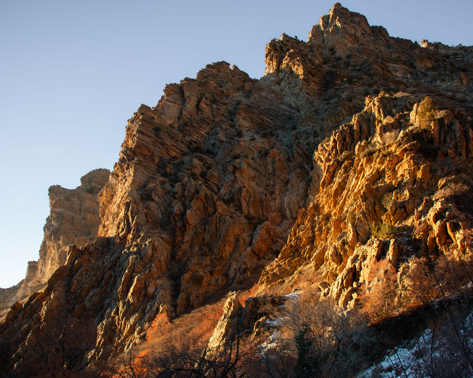 the rocky top of a mountain catches the low angled sun